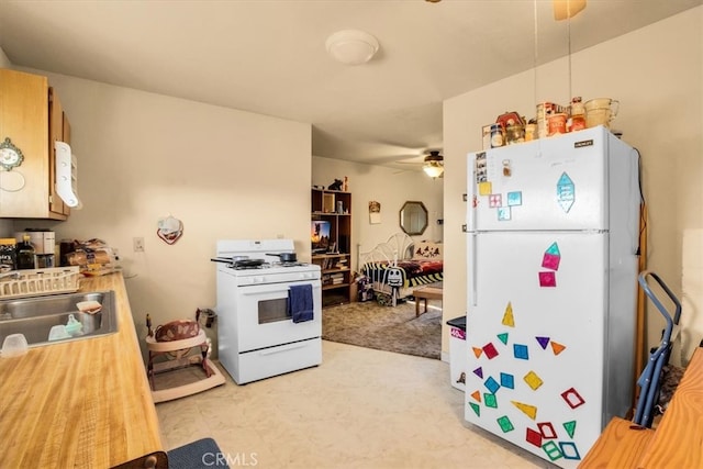 kitchen featuring white appliances, ceiling fan, and sink