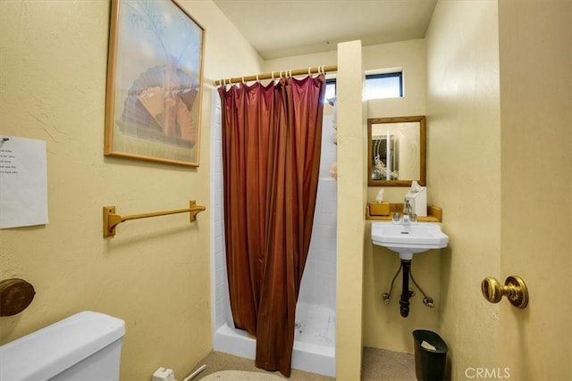 bathroom featuring toilet and curtained shower