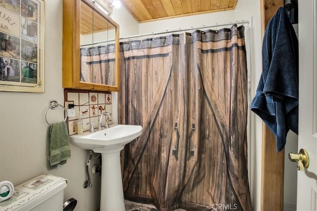 bathroom featuring curtained shower, toilet, and wooden ceiling