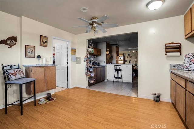 kitchen with ceiling fan, light wood-type flooring, and kitchen peninsula