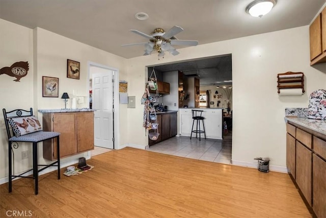 5975 Desert Star Rd Unit 1-2, Johnson Valley, CA 92285 - kitchen featuring baseboards, ceiling fan, brown cabinetry, and light wood-style flooring