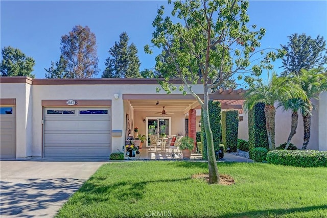 view of front of house with ceiling fan, a garage, and a front lawn