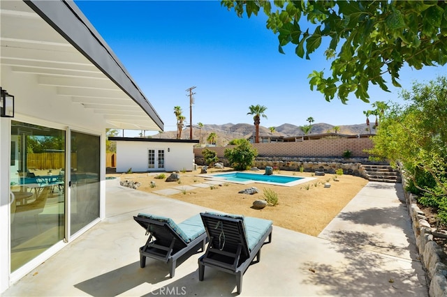 view of patio / terrace with a fenced in pool and a mountain view