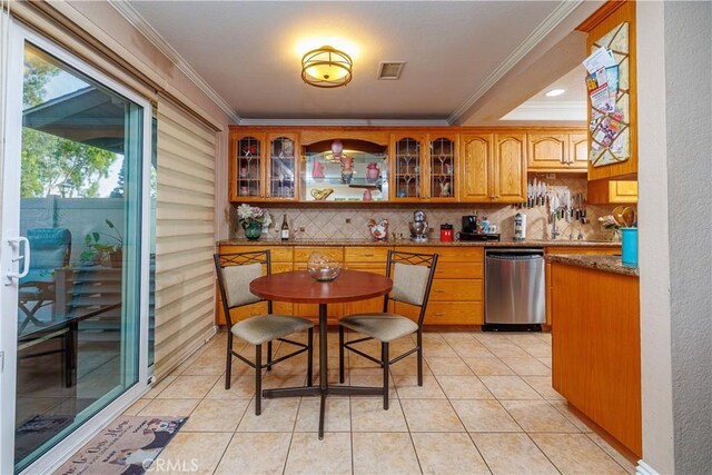 kitchen with tasteful backsplash, crown molding, dishwasher, and light stone countertops