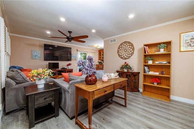 living room featuring crown molding, ceiling fan, and light wood-type flooring