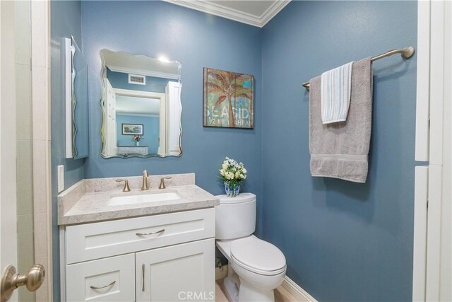 bathroom featuring vanity, toilet, and ornamental molding