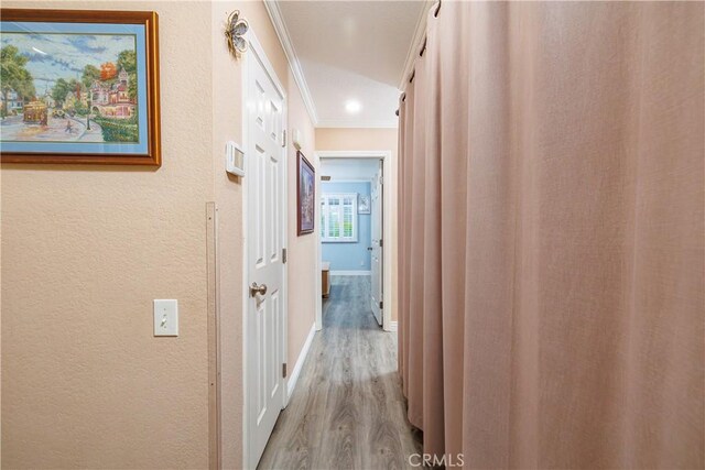 hall with hardwood / wood-style flooring and crown molding