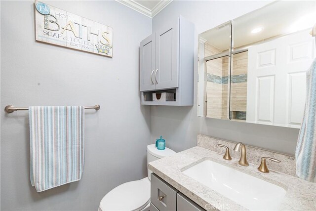 bathroom featuring toilet, vanity, an enclosed shower, and ornamental molding