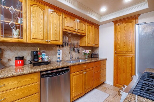 kitchen with light stone countertops, sink, stainless steel appliances, tasteful backsplash, and light tile patterned floors