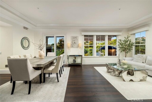 dining area with hardwood / wood-style flooring, ornamental molding, and a healthy amount of sunlight