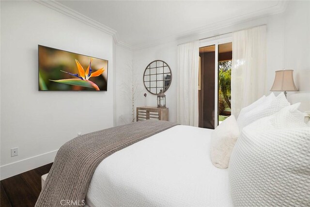 bedroom with hardwood / wood-style flooring, ornamental molding, and access to exterior