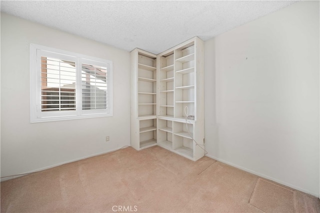 carpeted empty room featuring a textured ceiling