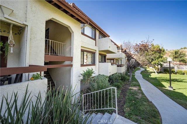 exterior space featuring a balcony and a yard