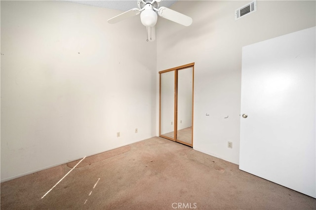 unfurnished bedroom with light carpet, a closet, and ceiling fan