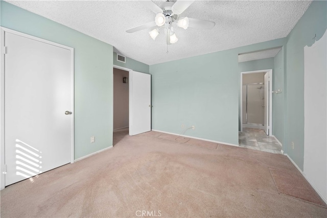 unfurnished bedroom with ceiling fan, light colored carpet, a textured ceiling, and a closet