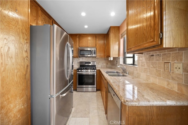 kitchen with light stone counters, backsplash, light tile patterned floors, stainless steel appliances, and sink