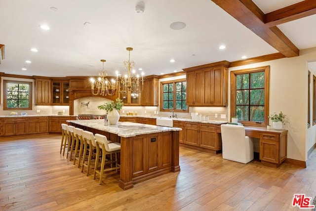 kitchen featuring decorative light fixtures, a center island, light wood-type flooring, and a wealth of natural light