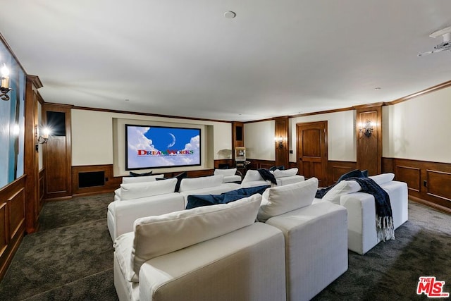 carpeted home theater with wooden walls and crown molding