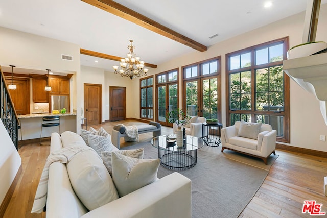 living room featuring beam ceiling, french doors, light hardwood / wood-style floors, and an inviting chandelier