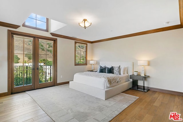 bedroom featuring access to outside, crown molding, french doors, and light wood-type flooring