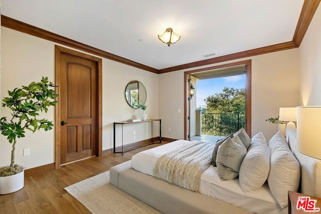 bedroom featuring light hardwood / wood-style flooring and crown molding