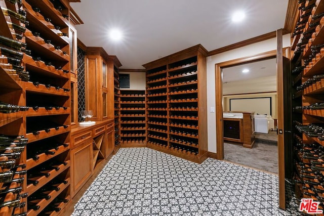 wine cellar with light colored carpet and crown molding