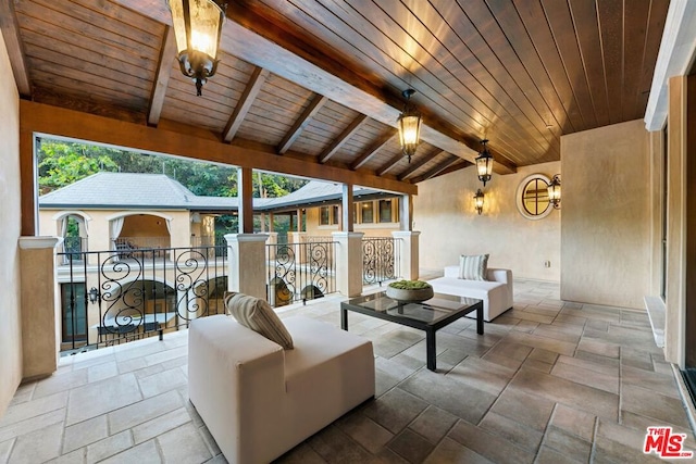 living room featuring vaulted ceiling with beams, plenty of natural light, and wood ceiling