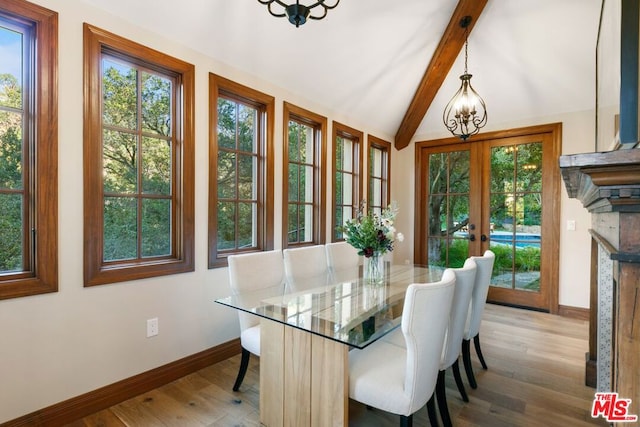 dining space featuring french doors, lofted ceiling with beams, a notable chandelier, and hardwood / wood-style flooring