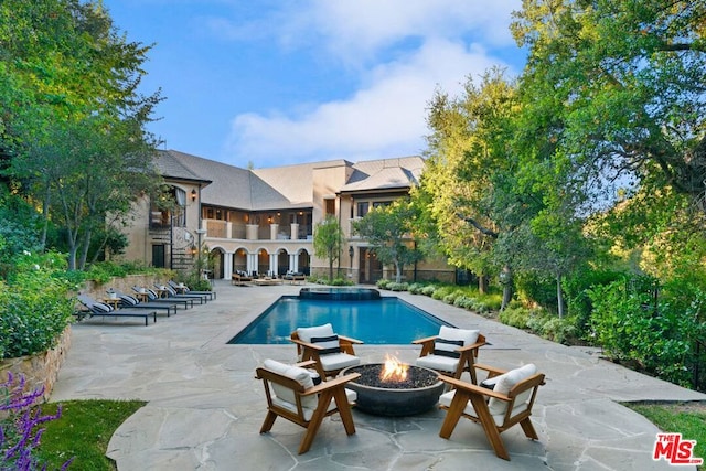 view of swimming pool featuring a fire pit and a patio area