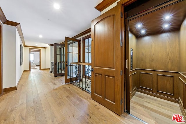 hall featuring elevator, crown molding, and light hardwood / wood-style floors