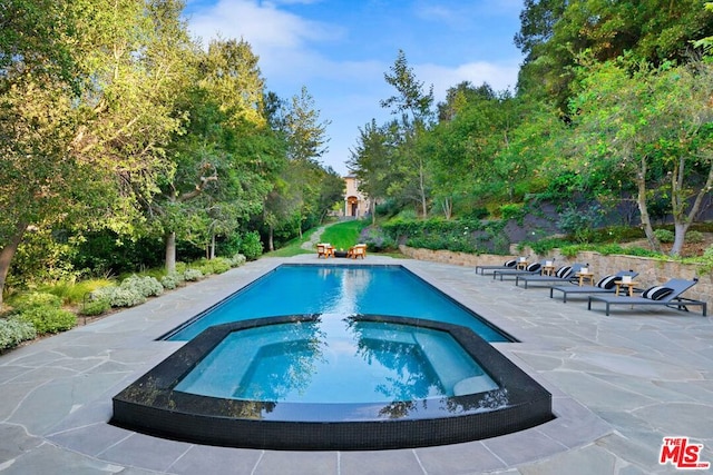 view of swimming pool featuring an in ground hot tub and a patio