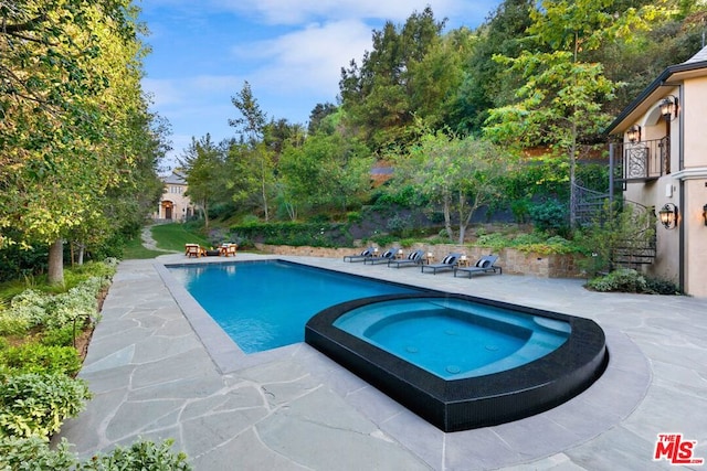 view of pool with a patio area and an in ground hot tub