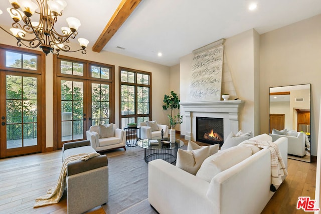 living room with beamed ceiling, light wood-type flooring, a fireplace, and french doors