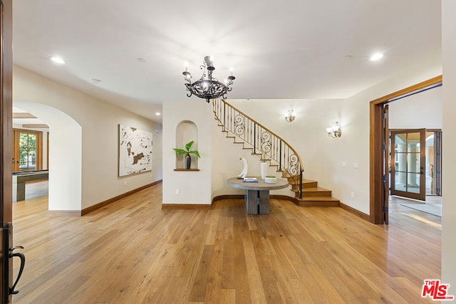 interior space with light hardwood / wood-style floors and an inviting chandelier