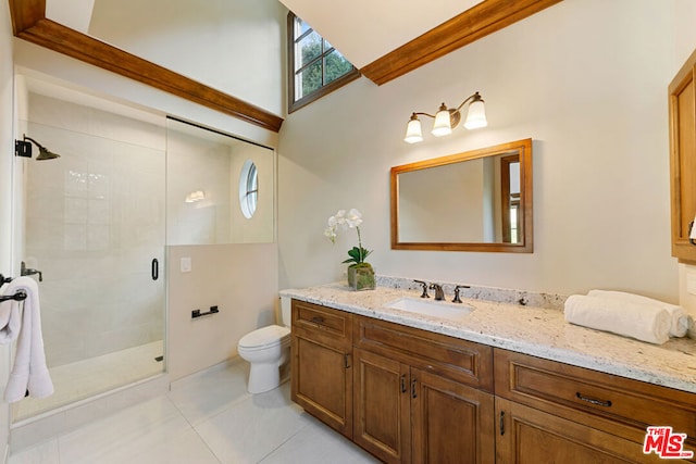 bathroom featuring tile patterned flooring, vanity, toilet, and walk in shower