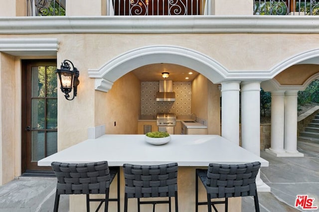 view of patio with exterior kitchen, a wet bar, and grilling area