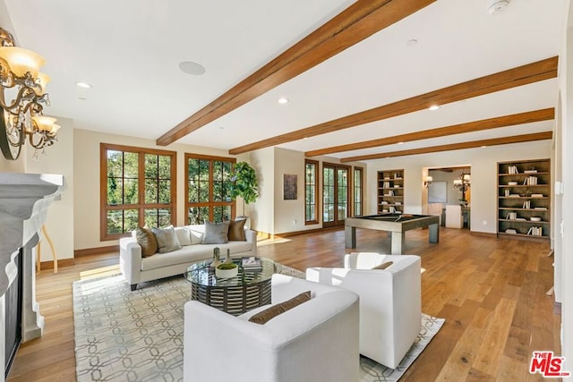 living room featuring a chandelier, beam ceiling, light hardwood / wood-style floors, and pool table