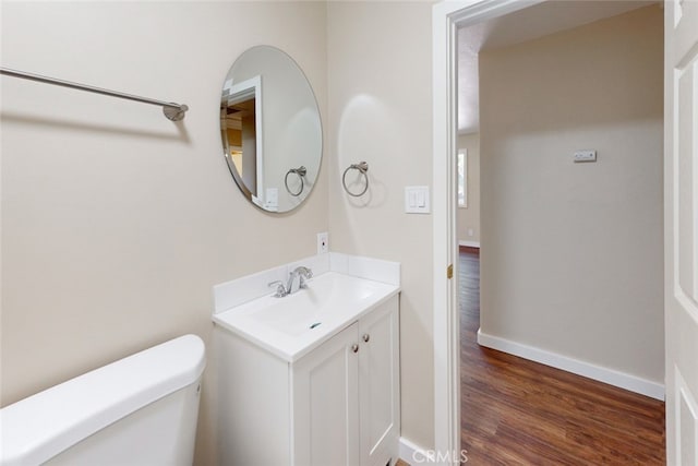 bathroom with hardwood / wood-style floors, vanity, and toilet