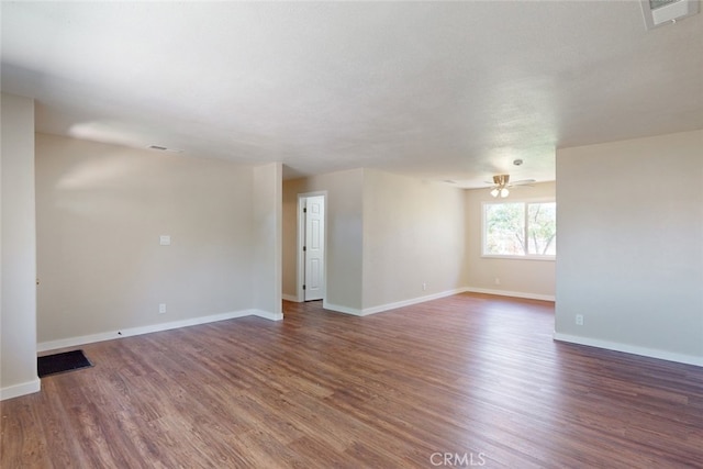 empty room with ceiling fan and dark wood-type flooring