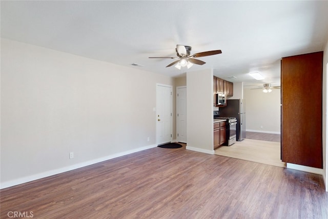 unfurnished living room featuring light wood-type flooring and ceiling fan