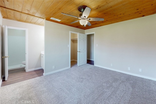 unfurnished bedroom featuring carpet, wood ceiling, ensuite bathroom, and ceiling fan