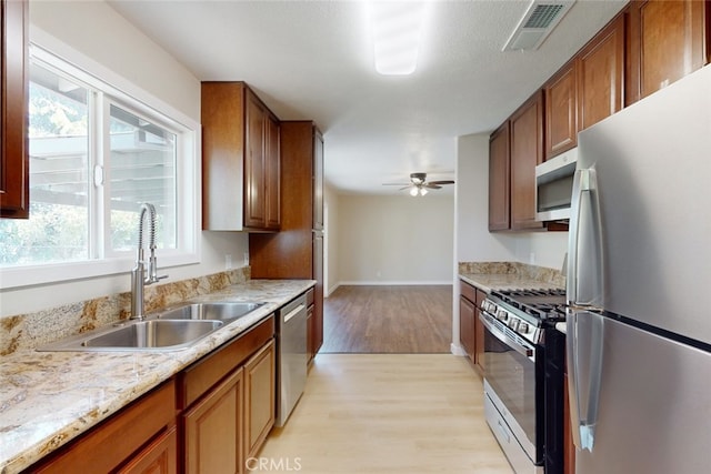 kitchen with light hardwood / wood-style floors, a healthy amount of sunlight, sink, and stainless steel appliances