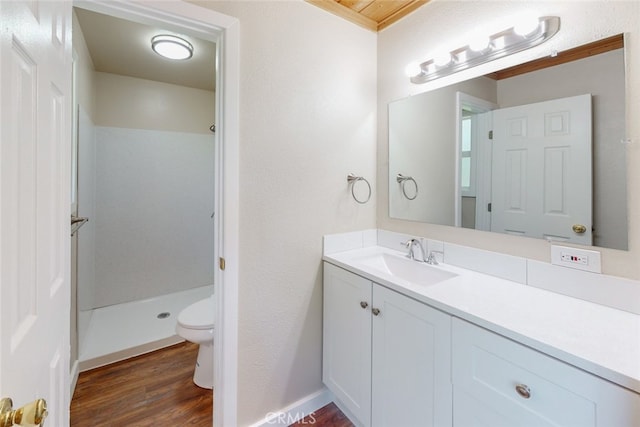 bathroom with a shower, hardwood / wood-style floors, vanity, and toilet