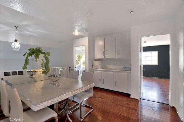 dining area with plenty of natural light and dark wood-type flooring