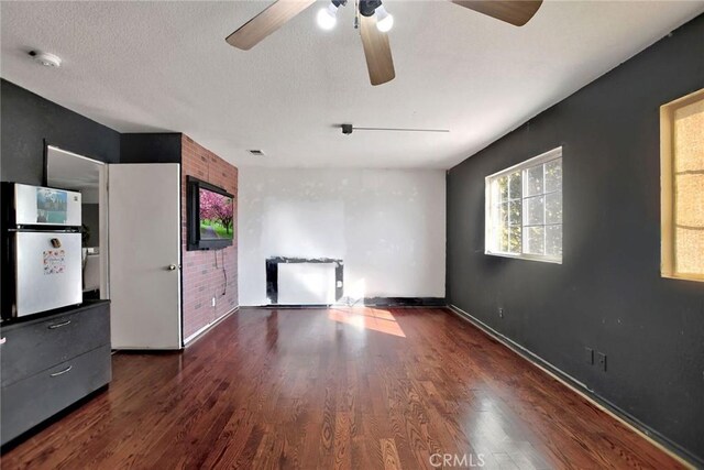 spare room featuring ceiling fan, dark hardwood / wood-style flooring, and a textured ceiling