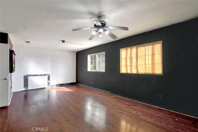 empty room featuring wood-type flooring, a textured ceiling, and ceiling fan