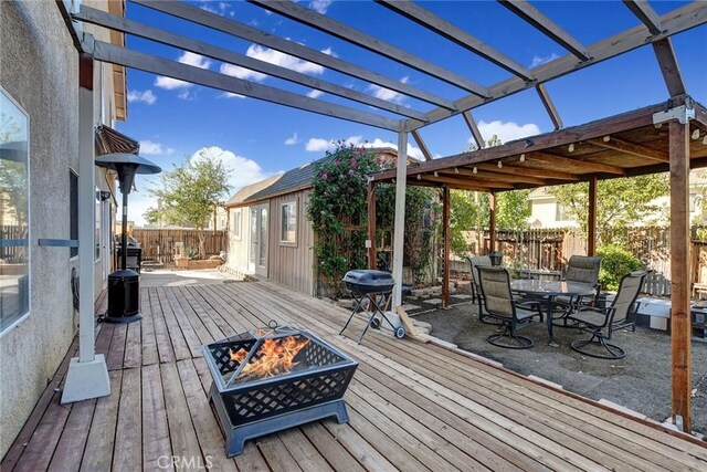 wooden deck featuring a pergola and a fire pit