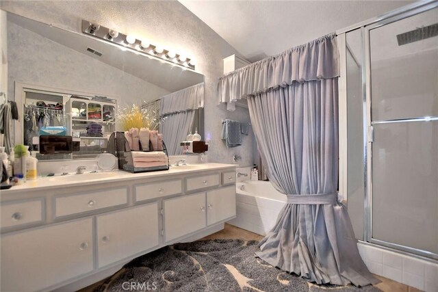 bathroom featuring shower with separate bathtub, vanity, and lofted ceiling