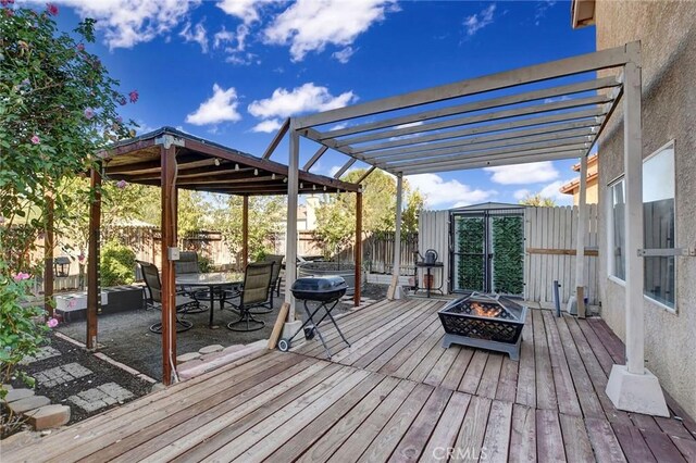 deck featuring a fire pit, area for grilling, and a pergola