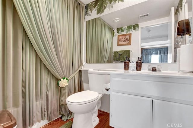 bathroom featuring wood-type flooring, vanity, and toilet